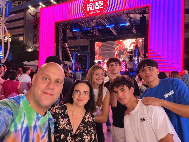 A group enjoying an evening together in front of a colorful outdoor music stage